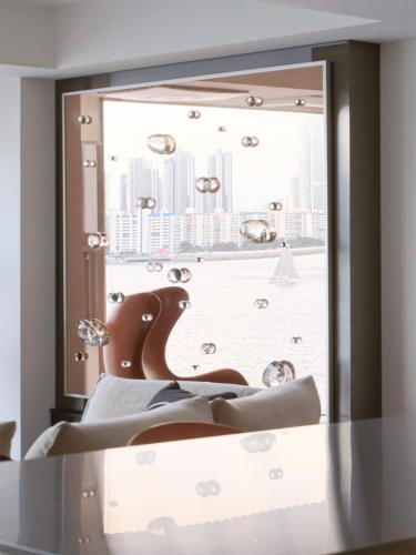 a mirror reflecting a window with a view of a city at B'amu Hotel in Busan