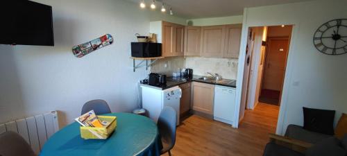 une petite cuisine avec une table dans une pièce dans l'établissement Studio Les Menuires - pied des pistes, aux Menuires