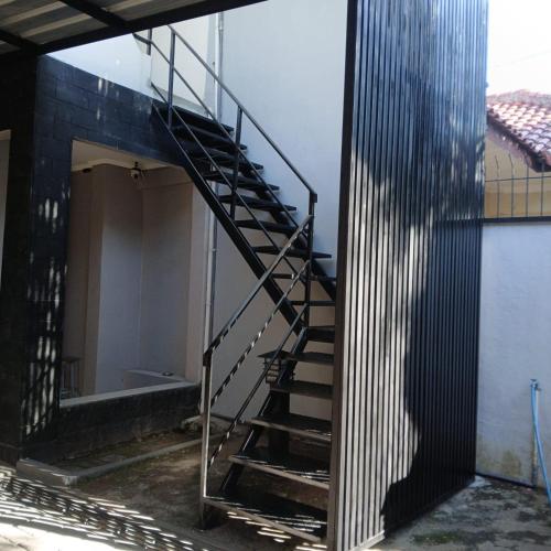 a metal staircase leading to a building with a door at Jhouse in center of Salatiga City in Salatiga