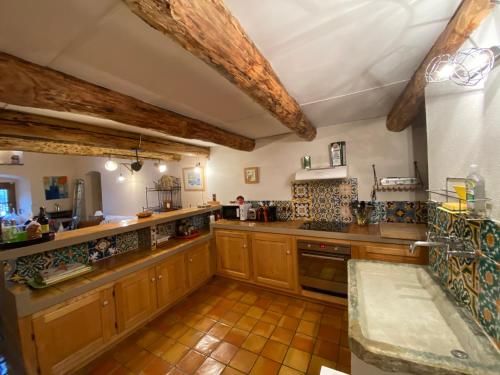 Il comprend une grande cuisine avec des placards en bois et du carrelage. dans l'établissement La Casetta, à Castifao