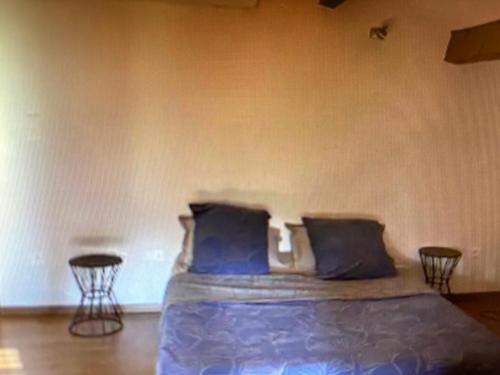 - une chambre avec un lit avec des oreillers bleus et 2 tables dans l'établissement Entre terre et mer, à Villeneuve-lès-Maguelone