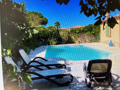 une piscine avec deux chaises longues à côté dans l'établissement Entre terre et mer, à Villeneuve-lès-Maguelone