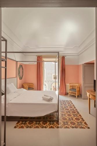 a bedroom with a large bed with pink walls at Palazzo Scammacca in Catania