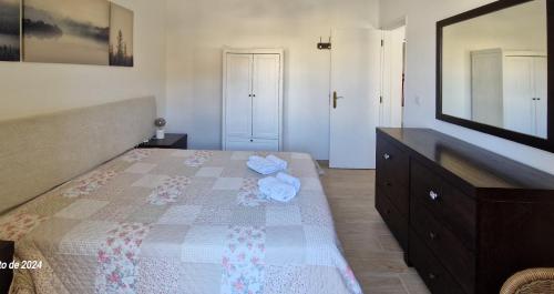 a bedroom with a bed with a dresser and a mirror at Apartamento Solaris T1 - Férias Albufeira in Albufeira