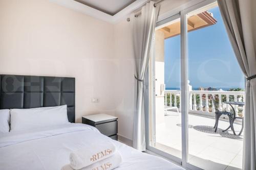 a bedroom with a bed and a balcony at Grand villa with pool, BBQ & stunning view by REMS in Arroyo de la Miel