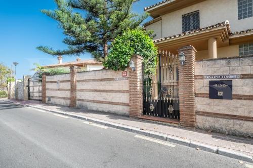 a house with a gate on the side of a street at Grand villa with pool, BBQ & stunning view by REMS in Arroyo de la Miel