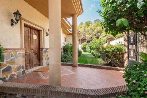 an entry to a house with a wooden door at Grand villa with pool, BBQ & stunning view by REMS in Arroyo de la Miel