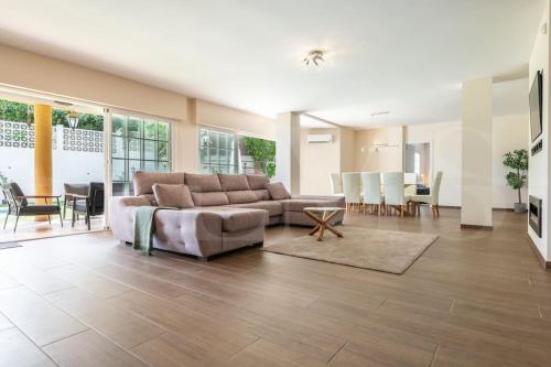 a large living room with a couch and a table at Grand villa with pool, BBQ & stunning view by REMS in Arroyo de la Miel