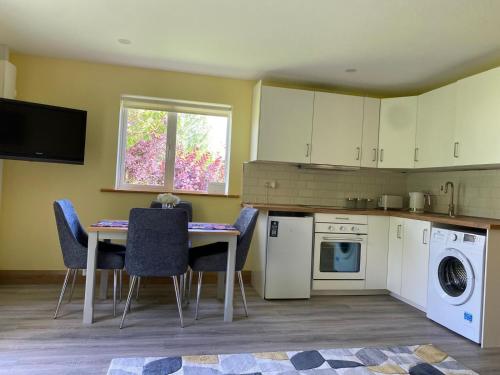 a kitchen with a table and chairs and a sink at Da's Cottage in Shillelagh