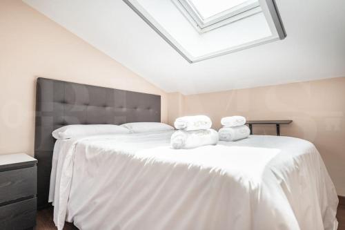 a bedroom with a large white bed with towels on it at Grand villa with pool, BBQ & stunning view by REMS in Arroyo de la Miel