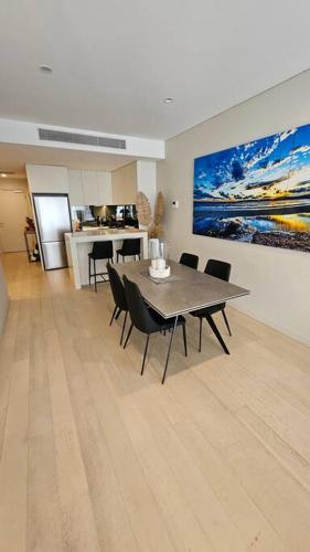 a dining room with a table and chairs and a kitchen at Bondi Junction Bellissima in Sydney