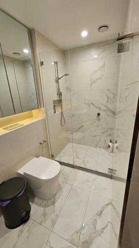 a bathroom with a toilet and a glass shower at Bondi Junction Bellissima in Sydney