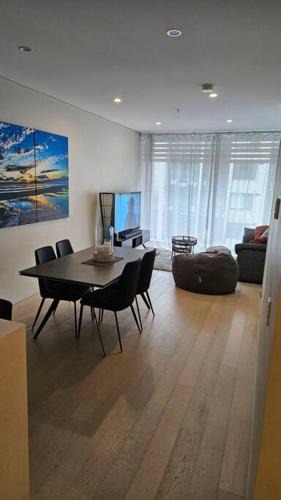 a living room with a dining room table and chairs at Bondi Junction Bellissima in Sydney
