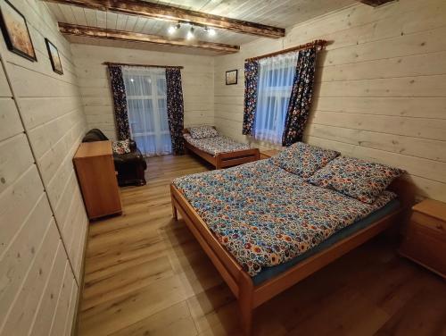 a bedroom with a bed in a wooden cabin at Wehikuł Czasu in Jędrzejówka