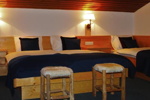 a bedroom with two beds and two stools at Alpenzeit in Flachau