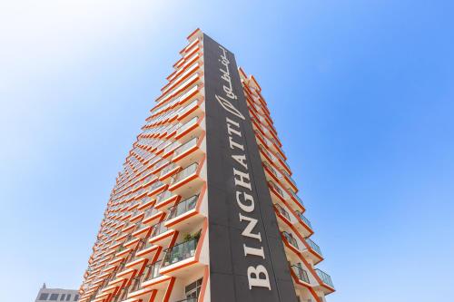 a tall building with a sign that reads apartments at Simply Comfort Vacation Homes Rental Binghatti Gateway Family 2BR with Balcony, Close to Dubai Mall & Burj Khalifa in Dubai
