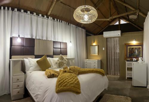 a bedroom with a large bed with white sheets at Lapa Lange Game Lodge in Mariental