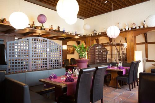 ein Restaurant mit rosa Tischen, Stühlen und Lampen in der Unterkunft Hotel Haus Union in Oberhausen