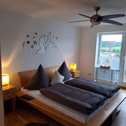 a bedroom with a bed and a ceiling fan at Ferienwohnung Inn-Blick in Passau