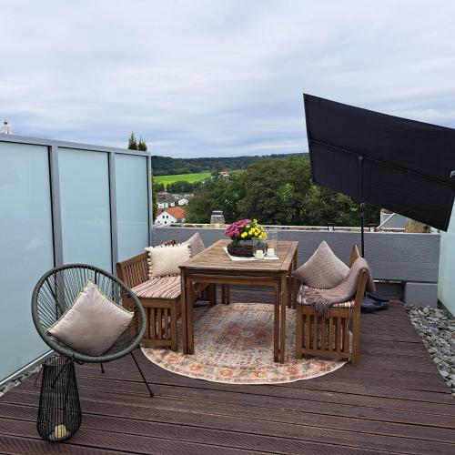 a patio with a table and chairs on a deck at Ferienwohnung Inn-Blick in Passau