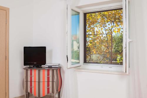 a television sitting on a table next to a window at Apartments Panorama in Trogir