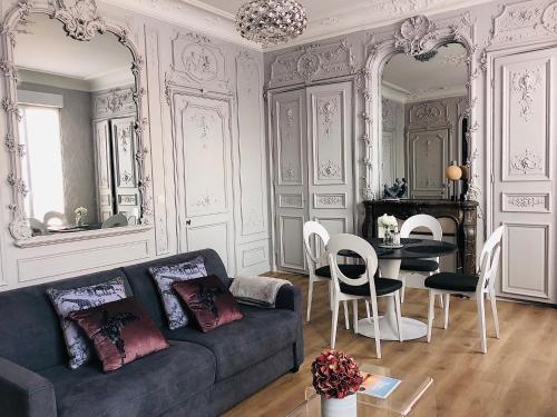 salon z kanapą i stołem w obiekcie Maison Gabriel Appartement PLUME w mieście Abbeville
