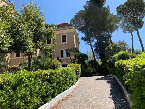 a walkway leading to a house with trees and bushes at Villa Angelina in Rome