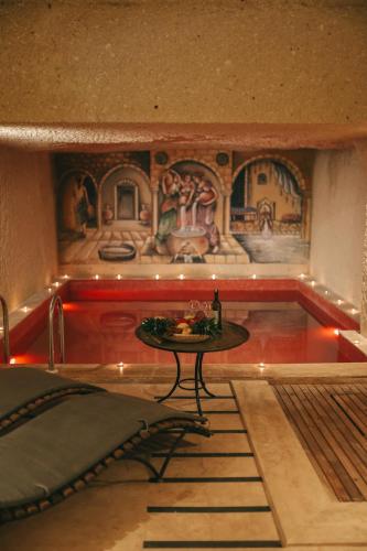 a room with a table and a painting on the wall at Cappadocia Vita Cave Hotel in Urgup