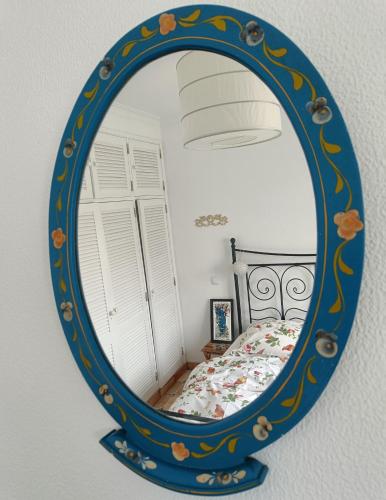 a mirror reflecting a bedroom with a bed in it at Casa Flow and Glow in Santiago do Cacém