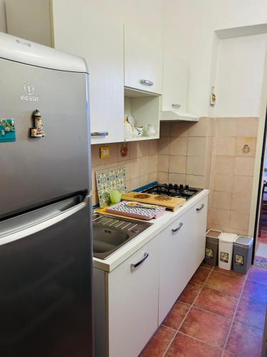 una cocina con refrigerador de acero inoxidable en Oikos, en Condofuri