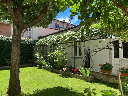 a house with a tree in the yard at Garden Lodge in Stresa