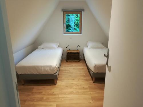two beds in a small room with a window at Merveille du Mont in Météren