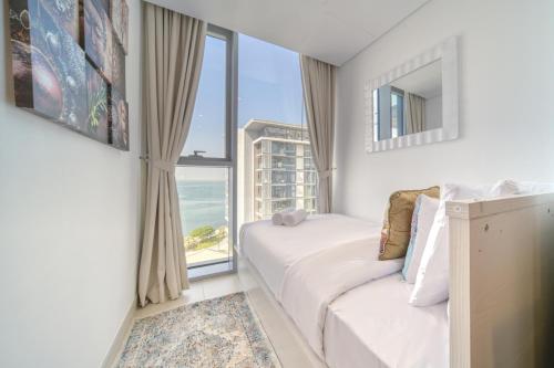 a bedroom with a bed and a large window at Lagom Vacation Home 2 Bedroom Apartment Blue Waters in Dubai
