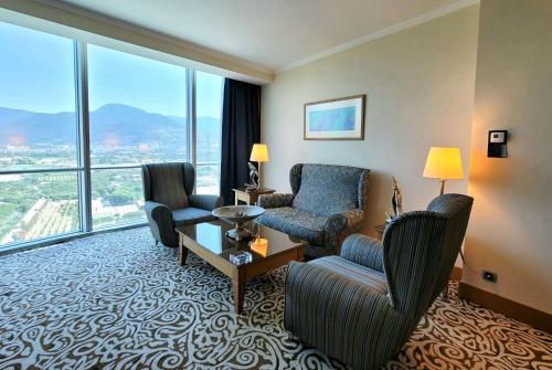 a hotel room with chairs and a large window at Wyndham Grand Izmir Ozdilek Thermal & Spa in Izmir