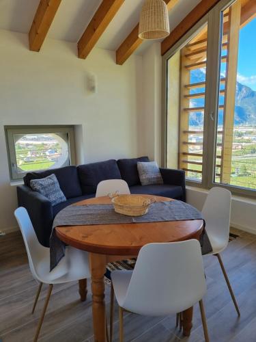 a living room with a table and a couch at Maso kreuzberg- Monolocale 3- vista montagne in Trento