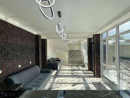 a lobby with couches and a staircase in a building at Urban Hotel in Almaty