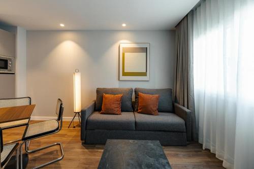 a living room with a couch and a table at Apartamentos 2H LIVING in León