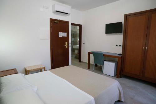 a bedroom with a bed and a desk and a table at Petit Hotel in Milazzo