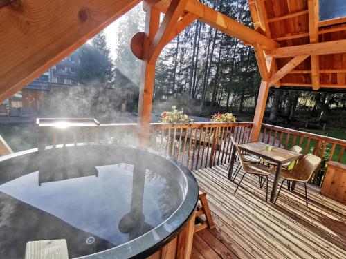 a hot tub on the deck of a cabin at Ribno Luxury Glamping in Bled