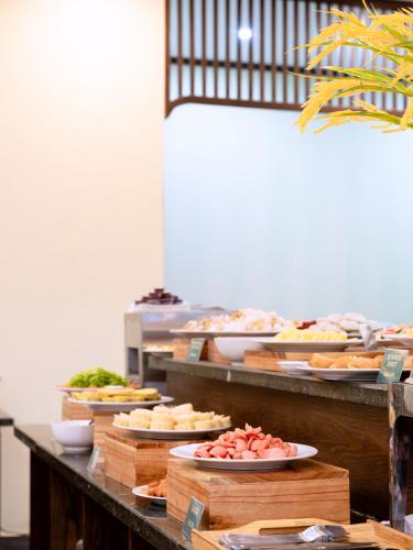 a buffet line with different types of food on plates at LumiGarden Tam Coc Resort in Ninh Binh