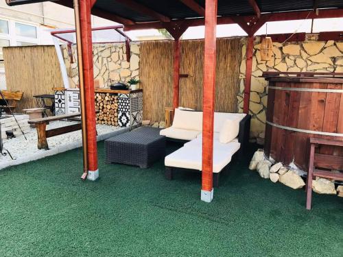 a gazebo with two white chairs and a bench at Dézsa Apartman Balatonalmádi in Balatonalmádi