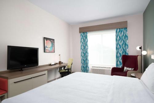 a hotel room with a bed and a flat screen tv at Hilton Garden Inn Houston/Clear Lake NASA in Webster