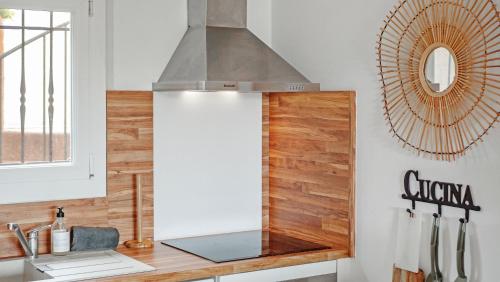 Il comprend une cuisine équipée d'une cuisinière. four supérieur à côté d'un comptoir dans l'établissement EASY MARINES - proche plage, à Cogolin