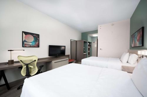 a hotel room with two beds and a desk at Hilton Garden Inn Houston/Clear Lake NASA in Webster