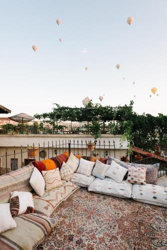 a long couch with pillows sitting on a balcony at Paradise Cappadocia Hotel & Rooftop in Göreme
