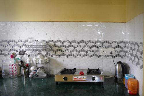 a kitchen with a counter with a white wall at DREAMS ABODE studio apartment in Guwahati