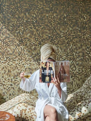 a person sitting on a bed with a book on their head at Meliá Desert Palm Member of Meliá Collection in Dubai