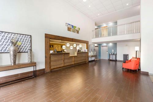 an empty lobby with a red chair and a table at Comfort Inn Meridian - Bonita Lakes in Meridian
