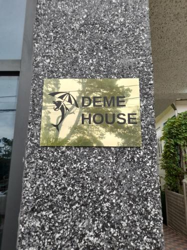 a sign on the side of a stone house at Guest House Deme in K'obulet'i