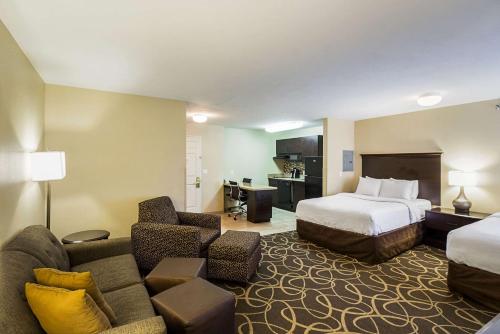 a hotel room with a bed and a couch at MainStay Suites Fargo - I-94 Medical Center in Fargo